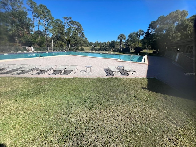 view of pool with a lawn