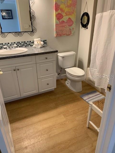 bathroom featuring toilet, vanity, and hardwood / wood-style flooring