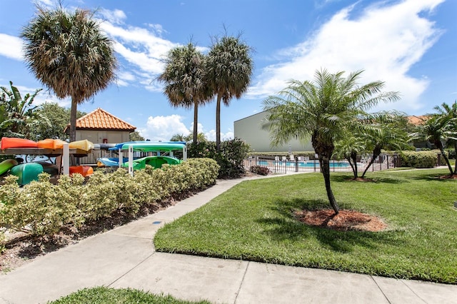 view of home's community featuring a lawn and a swimming pool