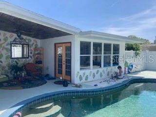 rear view of property featuring a fenced in pool