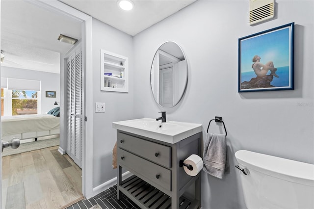 bathroom featuring wood-type flooring, vanity, and toilet