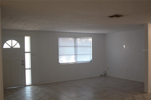 entrance foyer featuring tile patterned floors and a textured ceiling