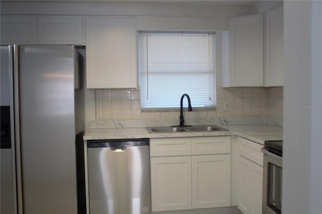 kitchen featuring tasteful backsplash, white cabinetry, sink, and appliances with stainless steel finishes