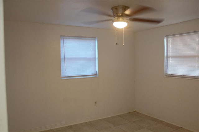 empty room with ceiling fan and light tile patterned floors