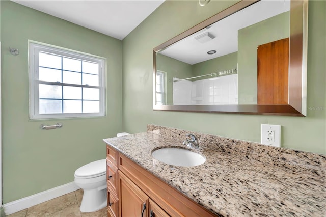 bathroom featuring tile patterned flooring, vanity, toilet, and walk in shower