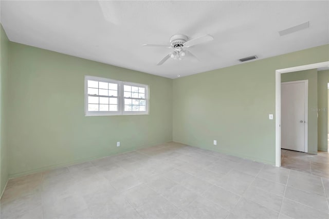 tiled spare room featuring ceiling fan