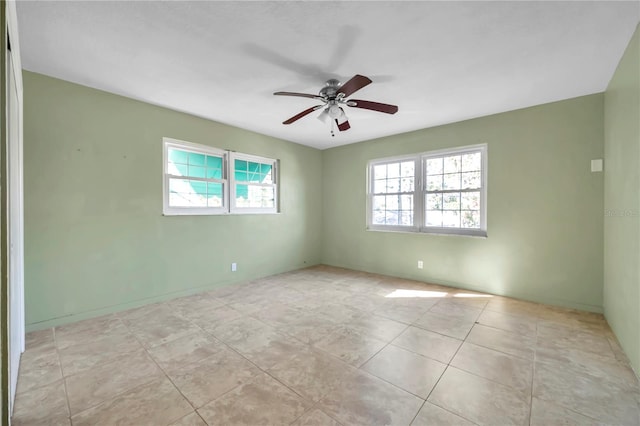 empty room with ceiling fan and light tile patterned flooring