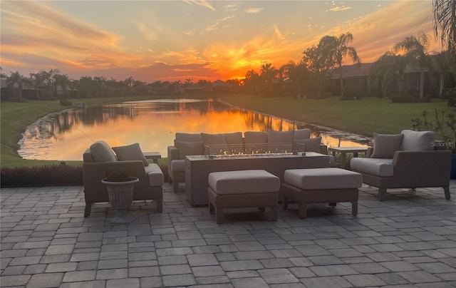 patio terrace at dusk with an outdoor living space and a water view