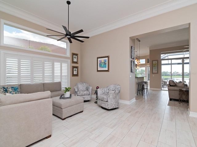 living room featuring ceiling fan with notable chandelier, a healthy amount of sunlight, and ornamental molding