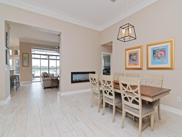 dining room with ceiling fan with notable chandelier and crown molding