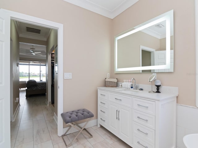 bathroom with ceiling fan, vanity, and ornamental molding