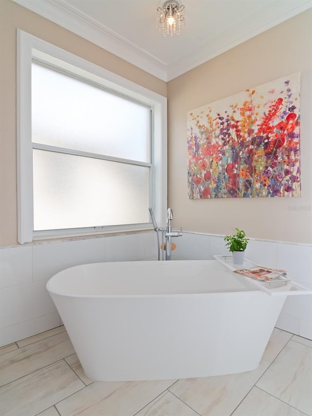 bathroom featuring a washtub, ornamental molding, and tile walls