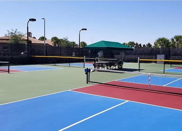 view of tennis court with basketball hoop