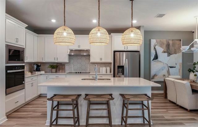 kitchen with white cabinetry, light wood-type flooring, and stainless steel appliances