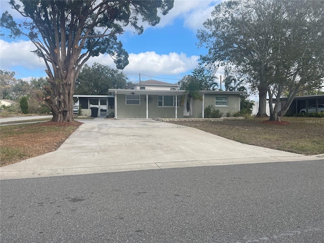 ranch-style home featuring a front lawn and a carport