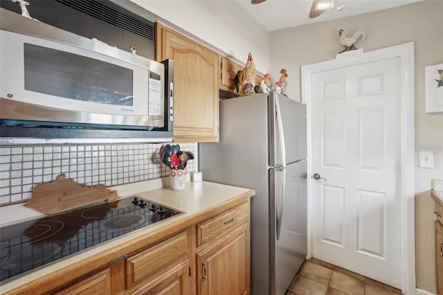 kitchen featuring ceiling fan, light tile patterned floors, appliances with stainless steel finishes, and tasteful backsplash