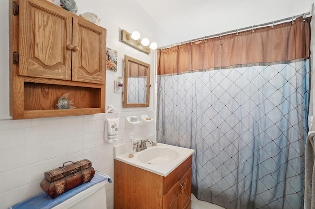 bathroom with a shower with curtain, vanity, toilet, and tile walls