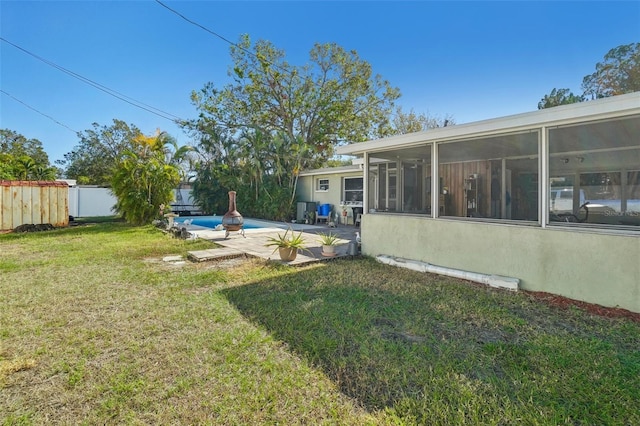 view of yard with a fenced in pool, a sunroom, and a patio