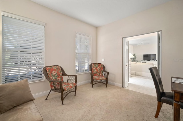 living area with ceiling fan and light carpet