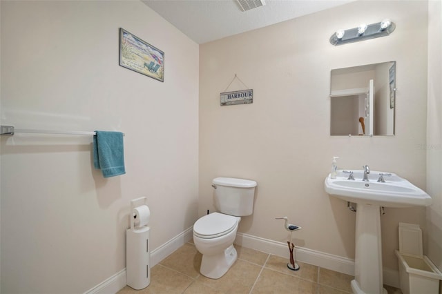 bathroom with toilet, tile patterned floors, and sink