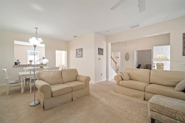 living room with light carpet and ceiling fan with notable chandelier