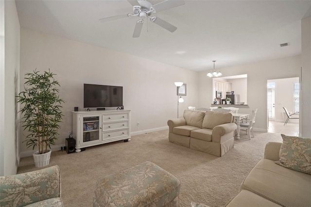 living room featuring light carpet and ceiling fan with notable chandelier