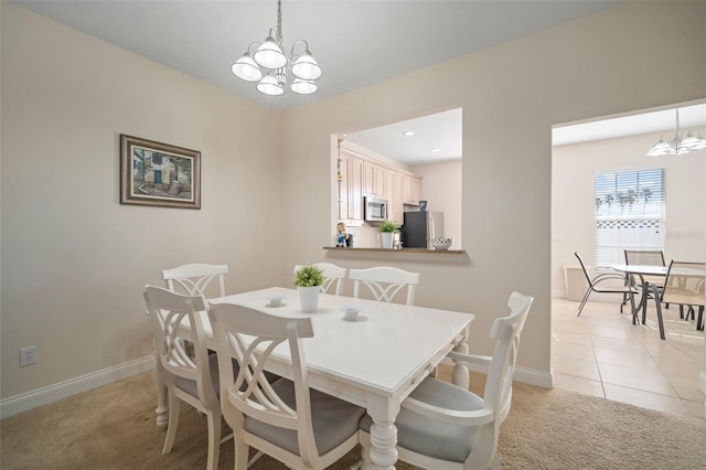 dining room with light tile patterned floors and a chandelier