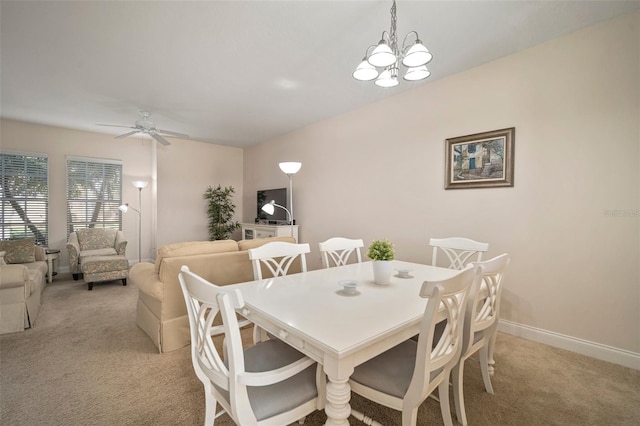 dining space featuring ceiling fan with notable chandelier and light colored carpet