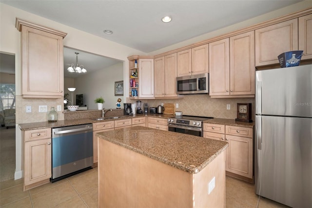 kitchen featuring light stone countertops, kitchen peninsula, decorative light fixtures, light brown cabinetry, and appliances with stainless steel finishes