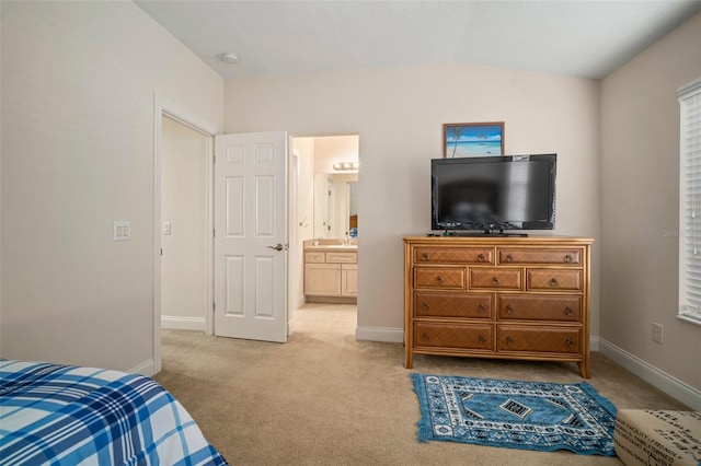 bedroom featuring connected bathroom, light colored carpet, and lofted ceiling