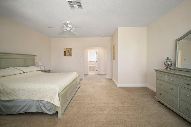 carpeted bedroom with ceiling fan, ensuite bathroom, and a textured ceiling