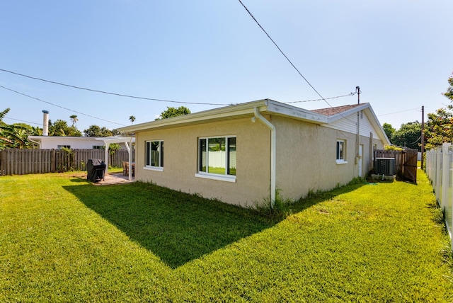 rear view of house with a lawn and central AC unit