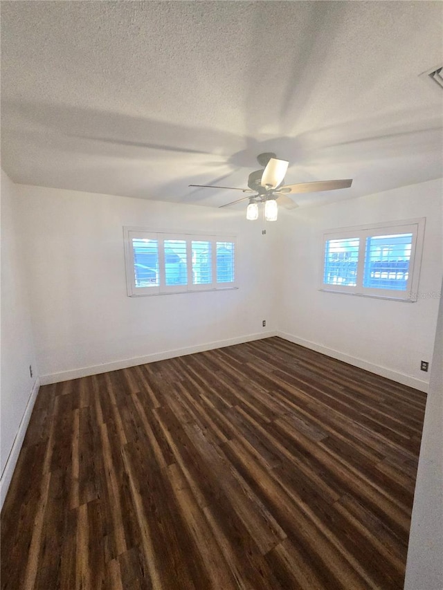 spare room with a textured ceiling, dark hardwood / wood-style floors, and plenty of natural light