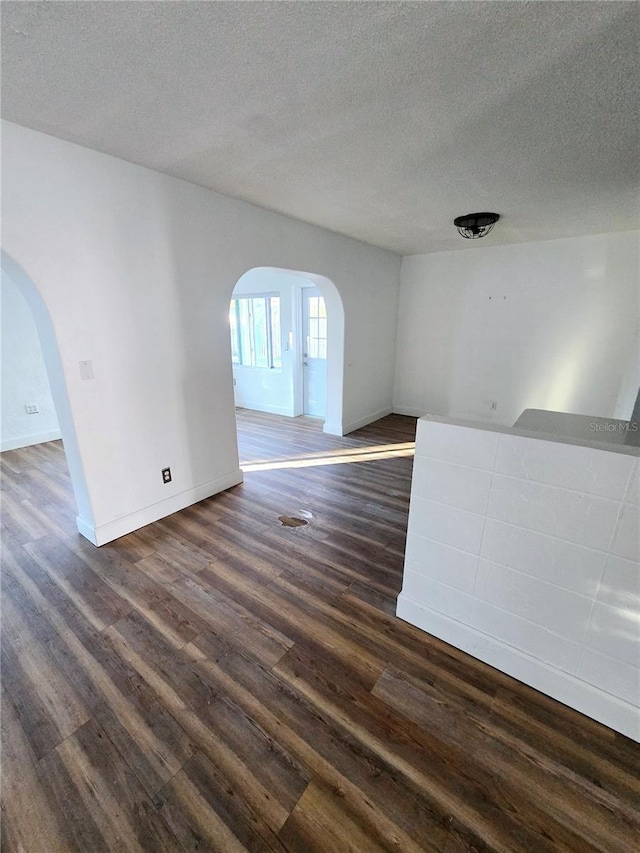 spare room featuring dark hardwood / wood-style floors and a textured ceiling