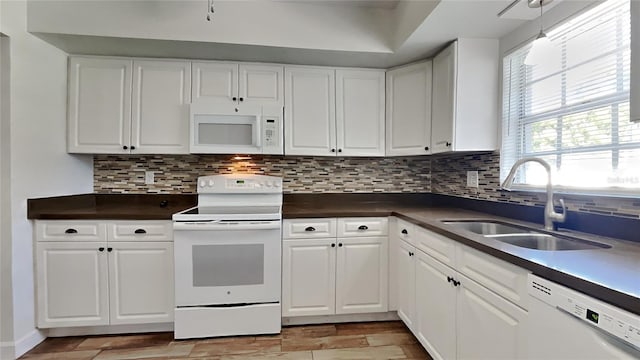 kitchen featuring white appliances, tasteful backsplash, white cabinetry, and sink