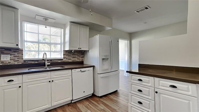 kitchen with white cabinetry, sink, white appliances, decorative backsplash, and light wood-type flooring