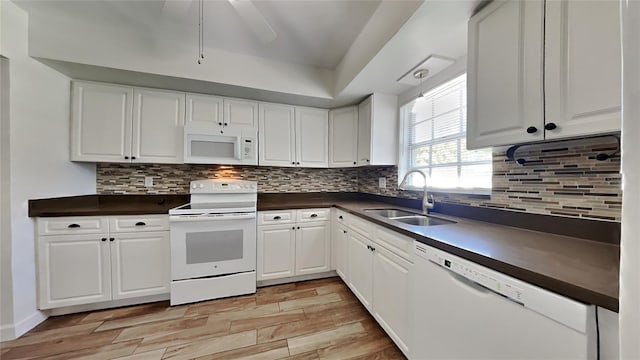 kitchen featuring white appliances, backsplash, sink, light hardwood / wood-style floors, and white cabinetry