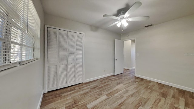 unfurnished bedroom with ceiling fan, a closet, and light hardwood / wood-style flooring