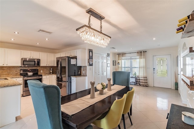 tiled dining area featuring a chandelier