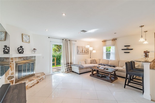 living room with light tile patterned floors and a fireplace