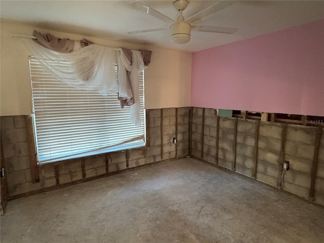 unfurnished room featuring ceiling fan and concrete flooring