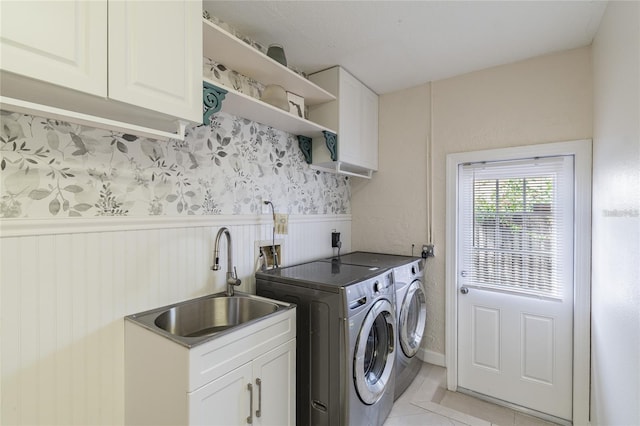 laundry area with washer and clothes dryer, sink, light tile patterned flooring, and cabinets