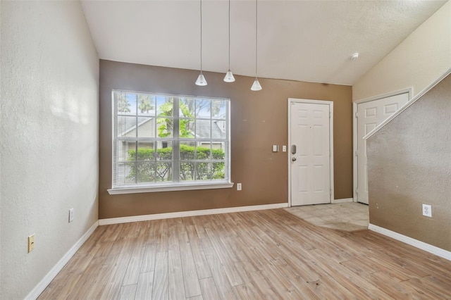 entryway with light hardwood / wood-style floors and vaulted ceiling