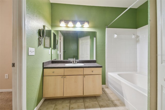 bathroom featuring tile patterned flooring, vanity, and tiled shower / bath