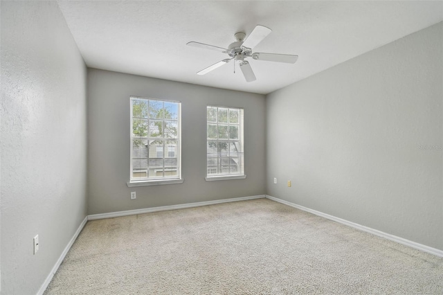 spare room with ceiling fan and carpet