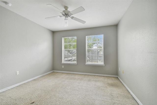 carpeted spare room featuring ceiling fan