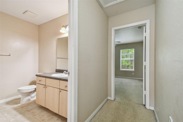 bathroom with tile patterned flooring, vanity, and toilet