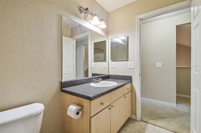 bathroom featuring tile patterned flooring, vanity, and toilet