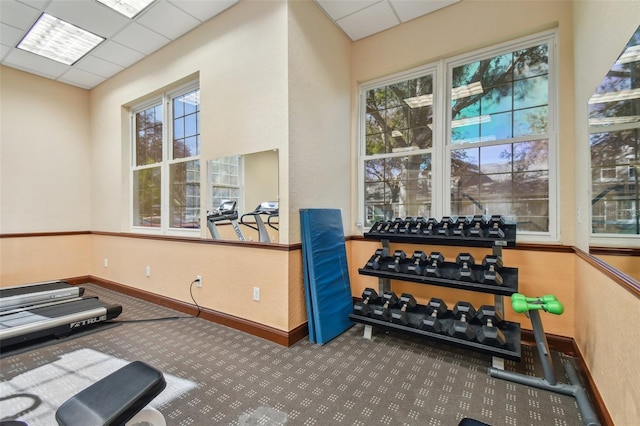 exercise room featuring a drop ceiling and plenty of natural light