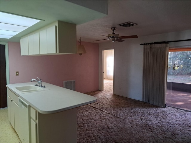 kitchen with sink, light carpet, dishwashing machine, a center island with sink, and white cabinets